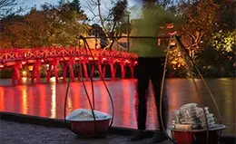 Pasea por el sereno lago Hoan Kiem y su icónico puente rojo